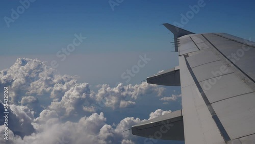 sunny day white fluffy clouds aircraft wing passenger window pov panorama 4k  photo