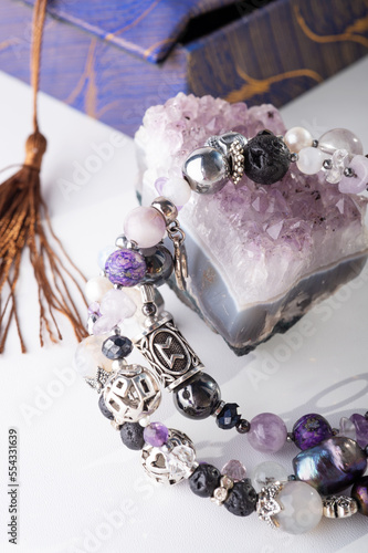 stylish jewelry bracelet with semiprecious and amethyst  crystal around  white background. hobby and fashion concept. close up photo