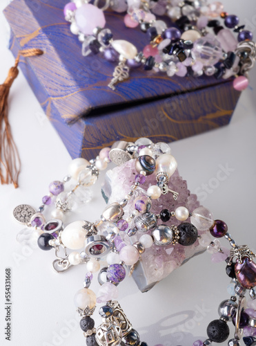 stylish jewelry bracelets with natural semiprecious and amethyst  crystal around  white background. hobby and fashion concept. close up photo