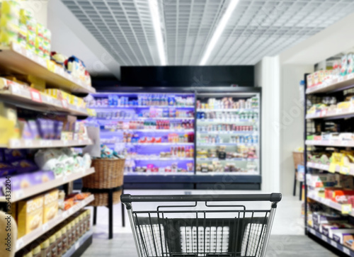 choosing a dairy products at supermarket.empty grocery cart in an empty supermarket,frozen food from a supermarket freezer