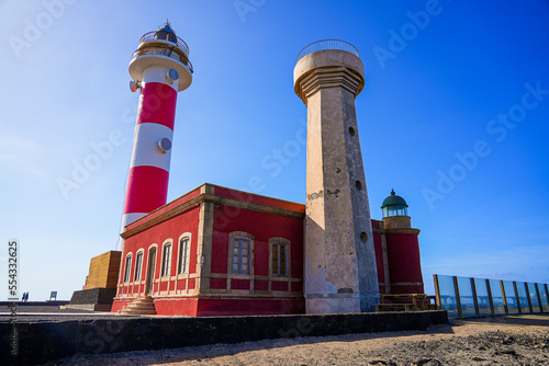Red and white striped tower with a 2-stories observation deck and a domed lantern of the lighthouse of El Toston on the north coast of Fuerteventura in the Canary Islands, Spain