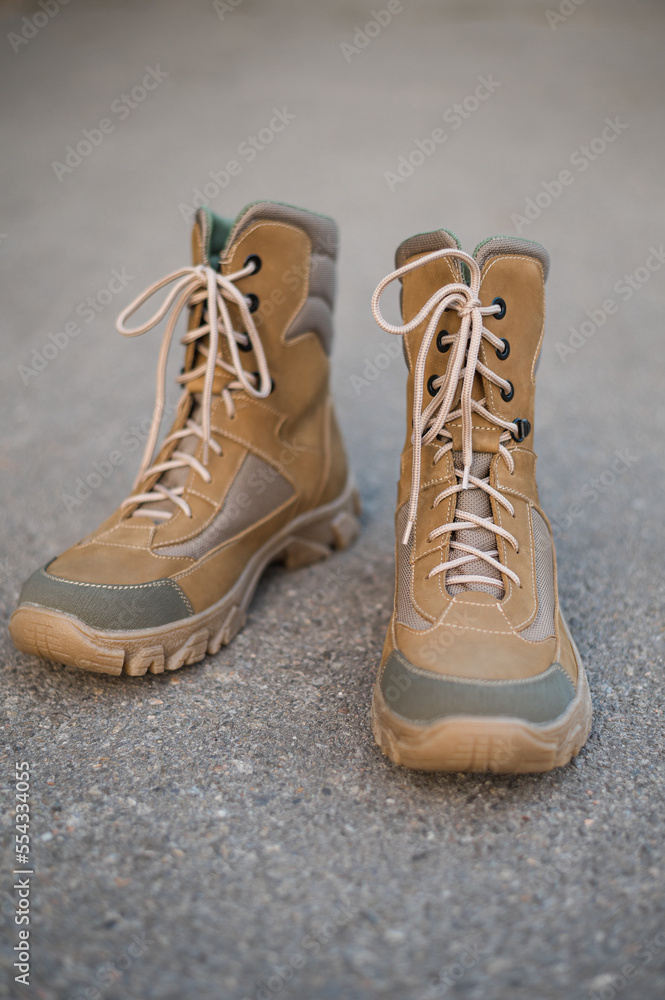 High-top lace-up sneakers in military color. Tactical army specialized sneakers for field conditions