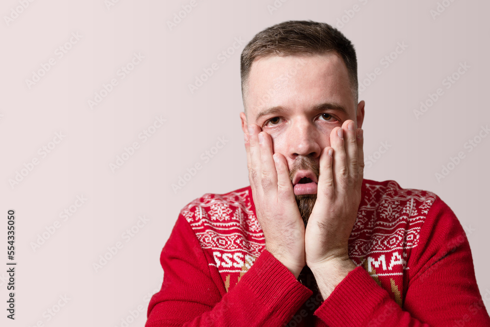 Young man feeling very distressed. Isolated on red background