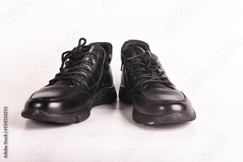 A pair of black winter boots with laces on a white background