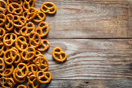 Salted mini pretzels on a wooden background, top view, copy space.