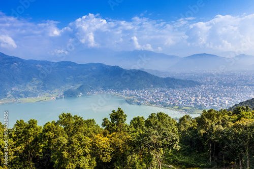 Looking across Fewa lake towards the city of Pokhara, Nepal on a sunny day, smog covering the city and surrounding areas, on a sunny autumn day; Pokhara, Kaski District, Nepal photo