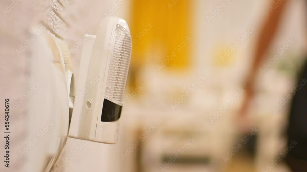 Hand switch on light in kitchen room. Special device connects power source and lit only when its dark at night to see switch for night walkers solution concept Hand switch on light in kitchen room. Special device connects power source and lit only when its dark at night to see switch for night walkers solution concept