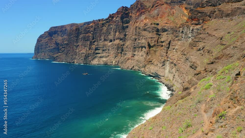 Flying at high speed over ocean water with huge rocks Los Gigantes cliffs. Tenerife Canary Islands. Aerial drone view at sunny day. Travel to Spain Europe. Flying at high speed over ocean water with huge rocks Los Gigantes cliffs. Tenerife Canary Islands. Aerial drone view at sunny day. Travel to Spain Europe.