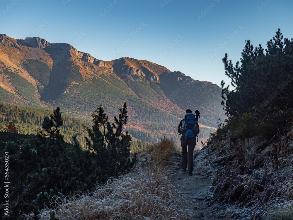Fototapeta premium Female hiker walking a path in the mountains