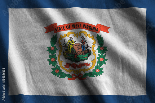 West Virginia US state flag with big folds waving close up under the studio light indoors. The official symbols and colors in fabric banner photo