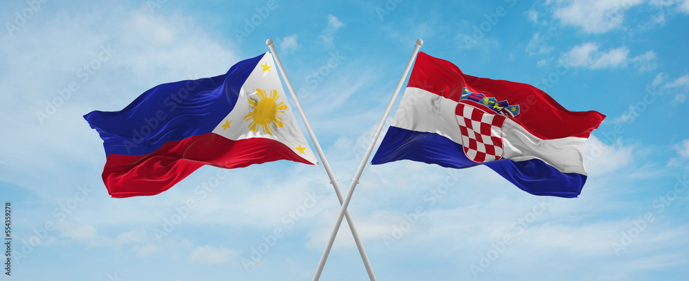two crossed flags Croatia and Philippines waving in wind at cloudy sky ...