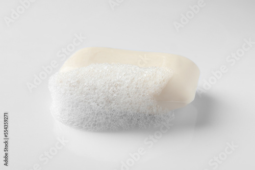 Soap with fluffy foam on white background