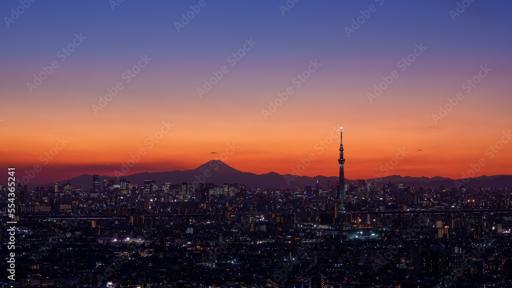 Cityscape of Tokyo with Mt. Fuji and Tokyo Skytree silhouette at dusk.