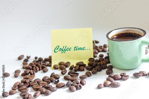 Чашка кофе с кофейными зернами и надписью на стикере