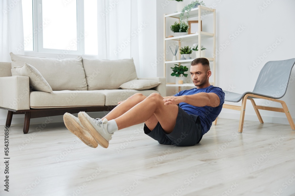 Man sportsman training at home, push-up exercises for arm, leg and back muscles, strong body and correct posture, the concept of health and beauty Man sportsman training at home, push-up exercises for arm, leg and back muscles, strong body and correct posture, the concept of health and beauty