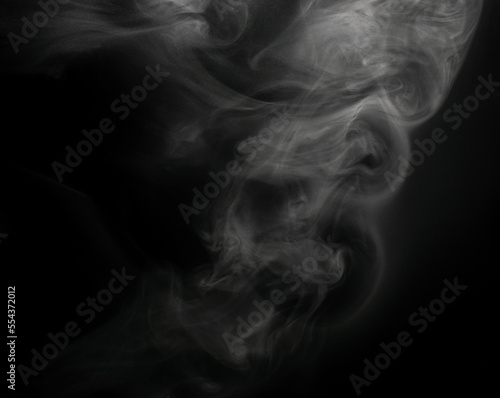 Fototapeta Naklejka Na Ścianę i Meble -  White puffs of smoke on a black background float mixing in bizarre chaotic patterns of thin threads
