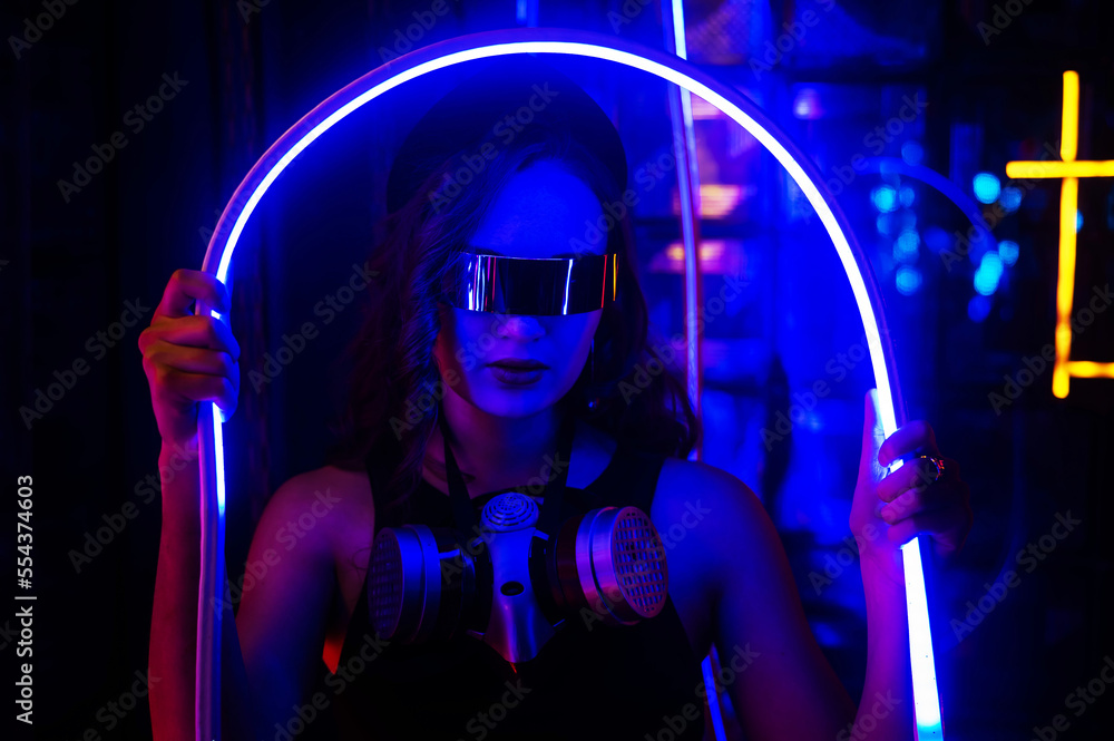 Caucasian woman in sunglasses posing in neon studio.
