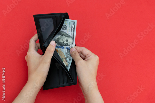 Woman hand holding a leather wallet with dollar