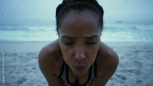 Tired, running and fitness with face of woman at beach for workout, cardio or endurance training in Brazil. Breathing, sweat and fatigue with portrait of runner for sprinting, marathon and challenge
