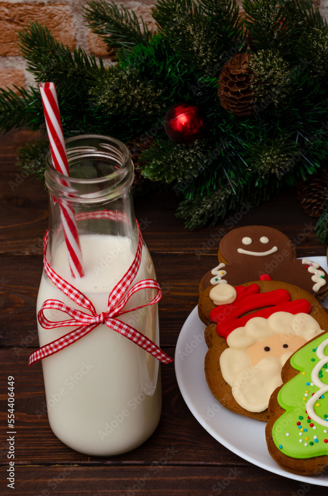 Bottle with milk and gingerbread on a wooden table. Christmas atmosphere.