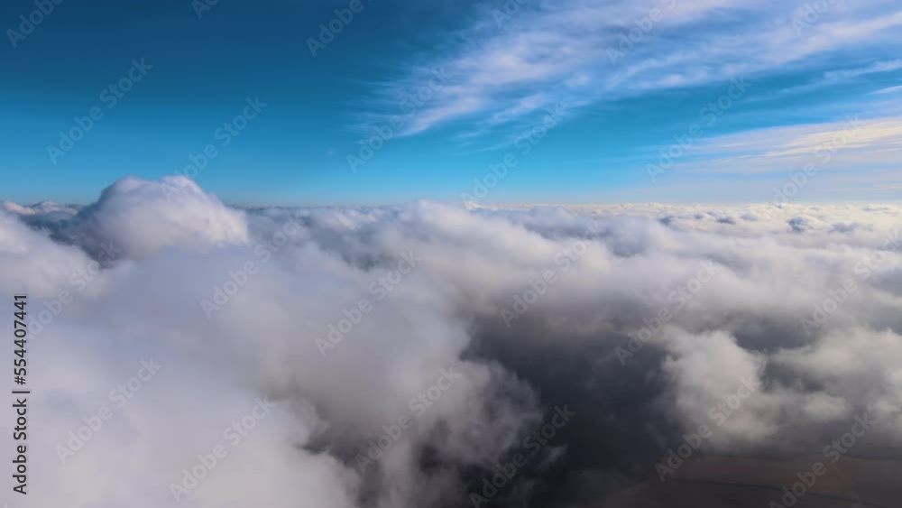 Aerial view from high altitude of earth covered with white puffy cumulus clouds on sunny day Aerial view from high altitude of earth covered with white puffy cumulus clouds on sunny day