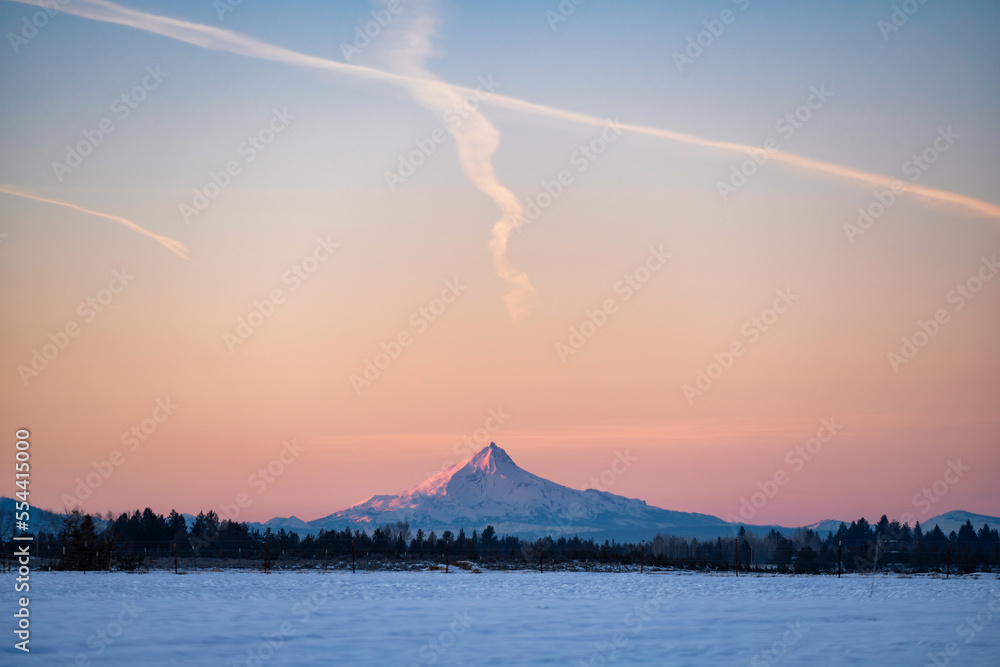 A field in the winter at sunset near Bend Oregon in Central Oregon with Mt Washington in the background
