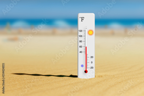 Sea coast at hot summer day. Fahrenheit scale thermometer in the sand shows plus 60 degrees