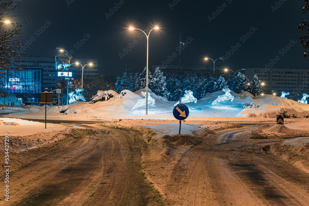 Mocno zasypane śniegiem droga i chodnik w mieście przemysłowym na Śląsku w Polsce, Jastrzębie-Zdrój nocą. - obrazy, fototapety, plakaty 