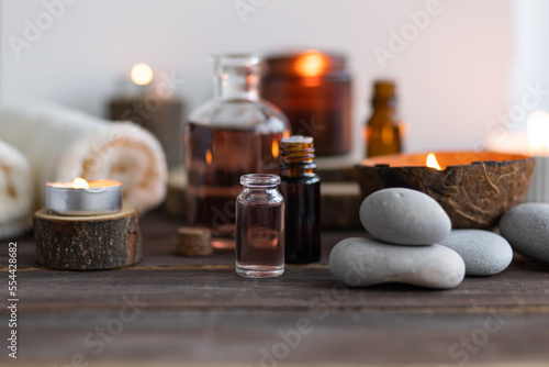 Concept of natural essential organic oils  Bali spa  beauty treatment  relax time. Atmosphere of relaxation  pleasure. Candles  towels  dark wooden background. Alternative oriental medicine