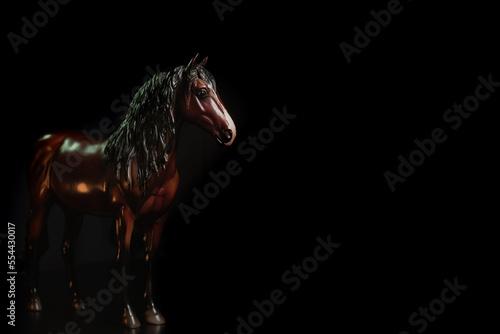 Black toy horse isolated on black background