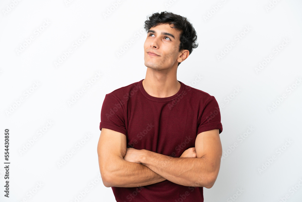 Young Argentinian man isolated on white background looking up while smiling Young Argentinian man isolated on white background looking up while smiling
