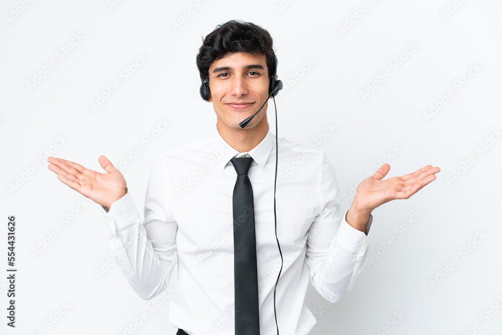 Telemarketer man working with a headset isolated on white background having doubts while raising hands Telemarketer man working with a headset isolated on white background having doubts while raising hands