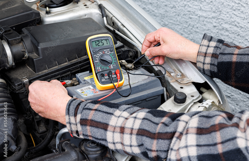 Fototapeta premium Mann testet Batterie für den Winter