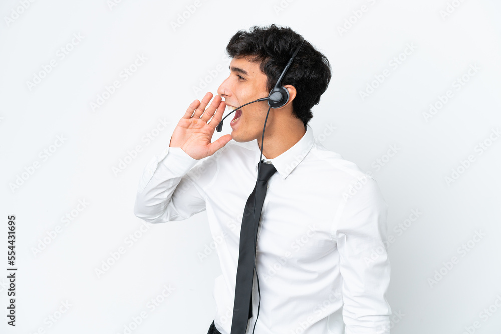 Telemarketer man working with a headset isolated on white background shouting with mouth wide open to the lateral Telemarketer man working with a headset isolated on white background shouting with mouth wide open to the lateral