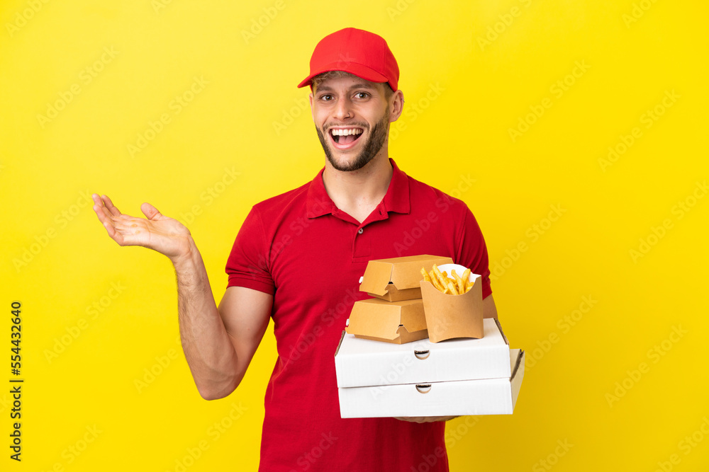 pizza delivery man picking up pizza boxes and burgers over isolated background with shocked facial expression pizza delivery man picking up pizza boxes and burgers over isolated background with shocked facial expression