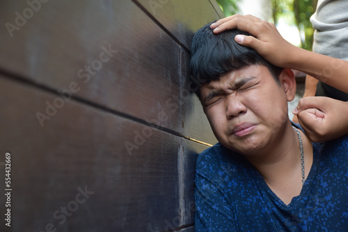 Asian secondary school boy was intimidated by bad habit students at the wall of the bathroom, soft and selecitve focus, bad habit students and teenagers concept. photo