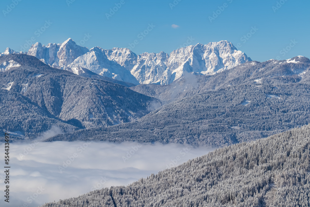 Scenic view of mountain summit Jof di Fuart (Vis) and Jof di Montasio in Julian Alps seen from Kobesnock near Bad Bleiberg, Carinthia, Austria, Europe. Heavy snow covered winter wonderland landscape