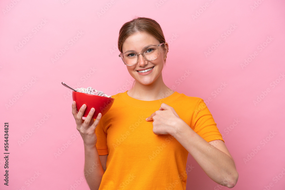 Young caucasian woman holding a bowl of cereals isolated on pink background with surprise facial expression Young caucasian woman holding a bowl of cereals isolated on pink background with surprise facial expression