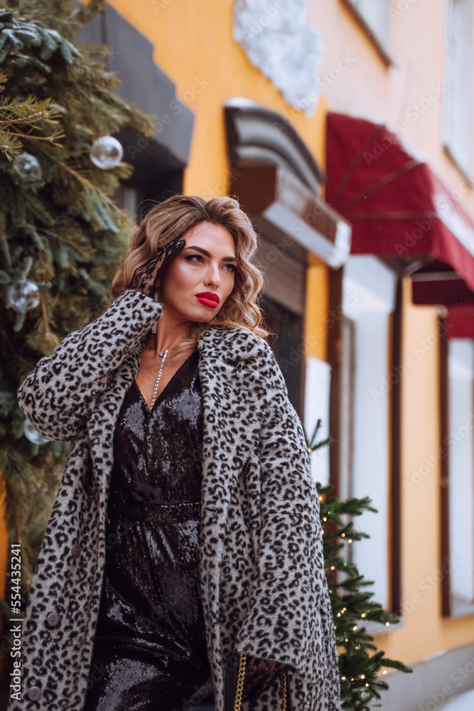 Gorgeous young woman with long hair on the street at Christmas. Festive decoration of city streets. Vertical. Gorgeous young woman with long hair on the street at Christmas. Festive decoration of city streets. Vertical.