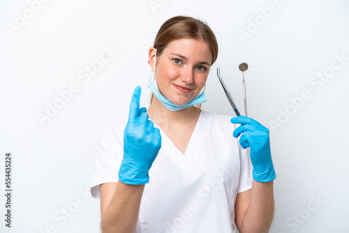 Dentist caucasian woman holding tools isolated on white background doing coming gesture