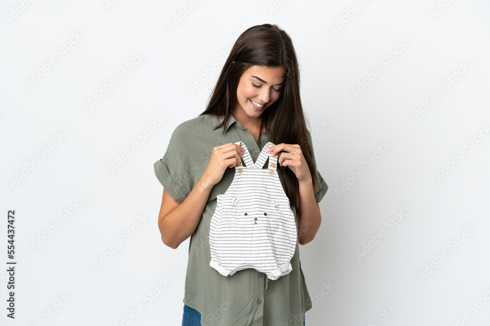 Young Brazilian woman isolated on white background pregnant and holding baby clothes Young Brazilian woman isolated on white background pregnant and holding baby clothes