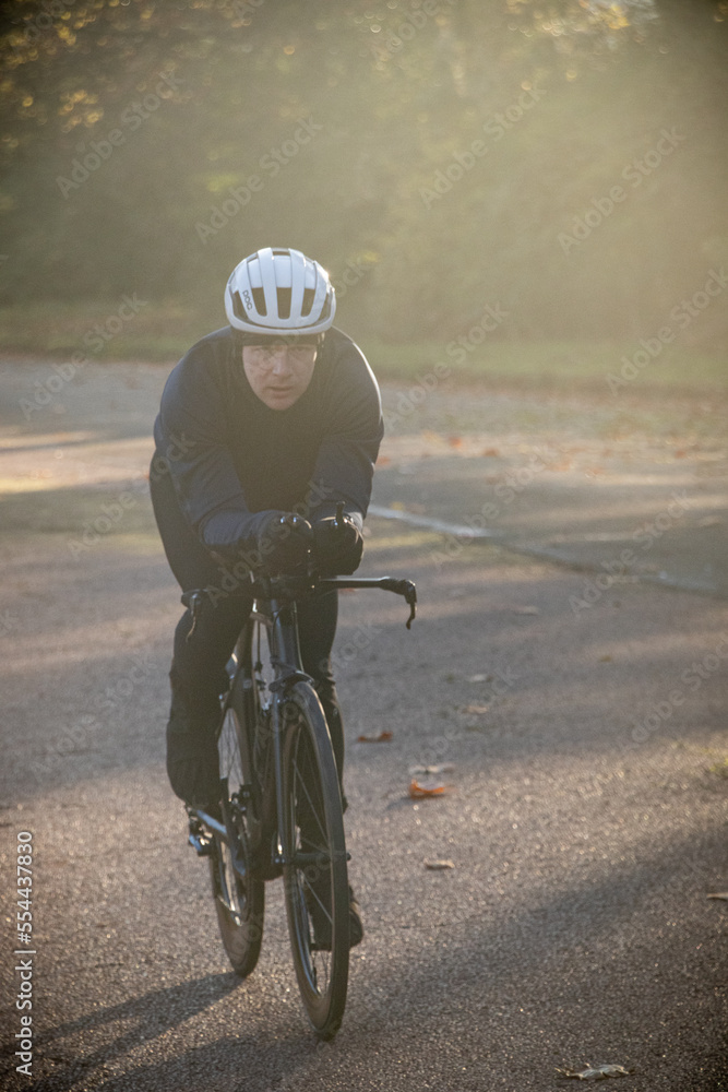 Obraz premium Professional cyclist training to ride fast on the Longchamp year in Paris in the cold winter on a Triahtlon racing bike