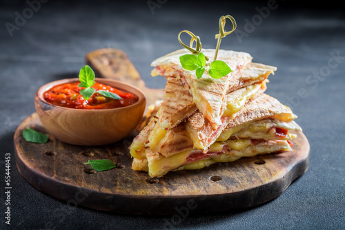 Spicy and hot quesadilla made of tortilla, ham and cheese.