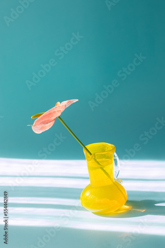 おしゃれで近代的な青い背景のアンスリウムと黄色い花瓶。