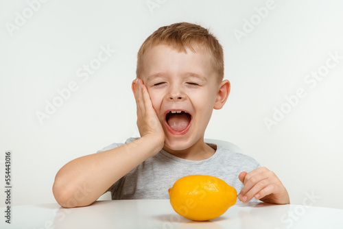 Little boy taste sour lemon emotional, with sore, facial emotions negative.