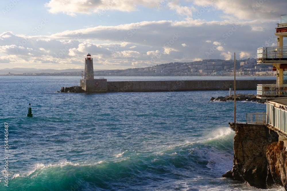 Port in the evening, beacon and the blue sea, lighthouse in the harbor in summer, seascape, Nice, France. Port in the evening, beacon and the blue sea, lighthouse in the harbor in summer, seascape, Nice, France.