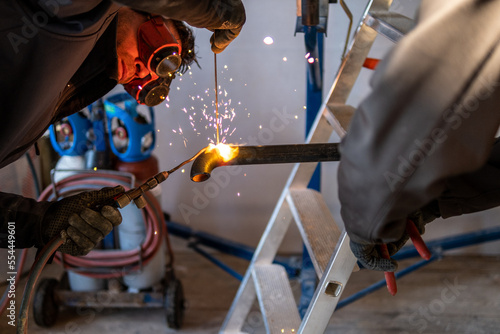 Man welding a gas pipe with flames and sparks