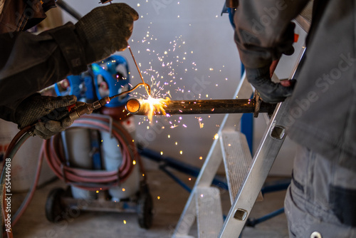Man welding a gas pipe with flames and sparks