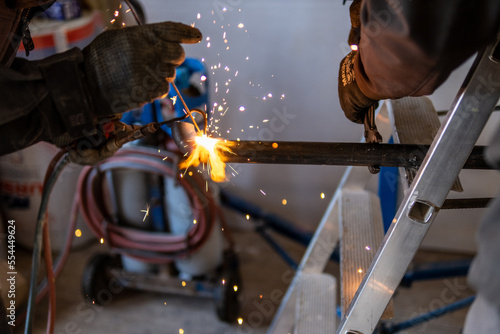 Man welding a gas pipe with flames and sparks