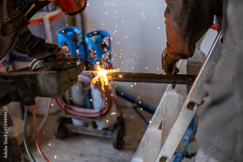 Man welding a gas pipe with flames and sparks
